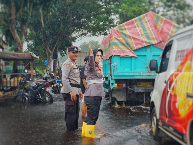 Aksi Perwira Polwan Rohil Atur Lalulintas saat Banjir Sambil Sosialisasi Pemilu