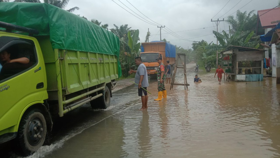 Curah Hujan Tinggi Air Sungai Meluap Babinsa Sertu Rizaefendi Koramil 01/Rengat Atur Lalu Lintas