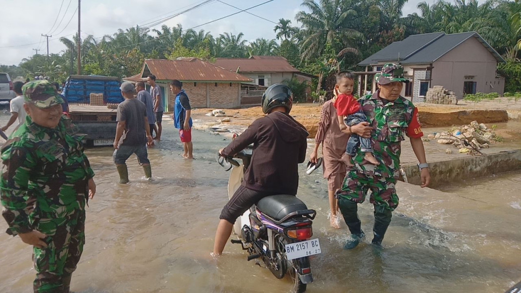 Akibat Banjir Yang Melanda Babinsa Koramil 01/Rengat Membantu Warga Dan Mengatur Arus Lalu Lintas