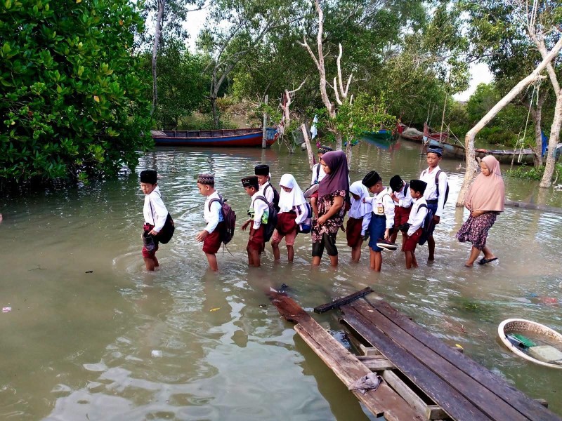 Akibat Jalan Rusak Dan Tenggelam, Anak Sekolah Terpaksa Mengarungi Air Pasang Untuk Menuntut Ilmu.
